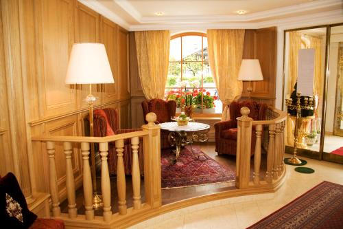 a living room with a staircase and a table and chairs at Gartenhotel Maria Theresia in Hall in Tirol