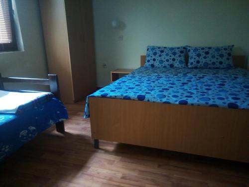 a bedroom with a bed with a blue comforter at Lile Pestani Accommodation in Peštani