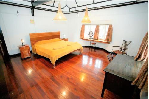 um quarto com uma cama e piso em madeira em Kiloran House em Nairobi