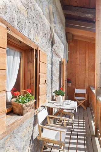 a patio with a table and chairs on a stone wall at Albergo Diffuso Sauris in Sauris Di Sopra in Sauris