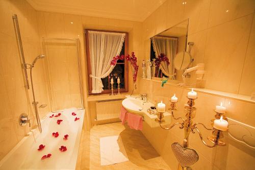 W łazience znajduje się wanna, umywalka i prysznic. w obiekcie Gartenhotel Maria Theresia w mieście Hall in Tirol