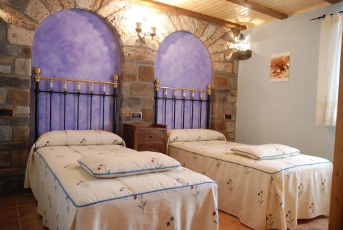 two beds in a room with purple arches at Apartamento el Patio Casa Cajal in Torla