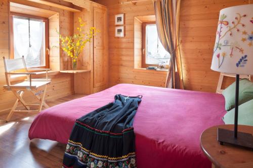 a bedroom with a bed in a wooden cabin at Albergo Diffuso Sauris in Sauris Di Sopra in Sauris
