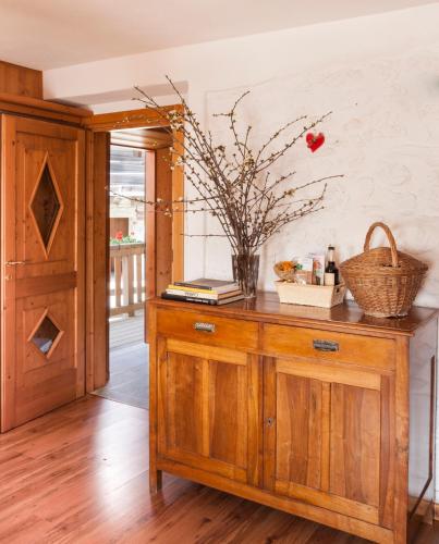 a wooden cabinet with a vase of flowers on it at Albergo Diffuso Sauris in Sauris Di Sopra in Sauris