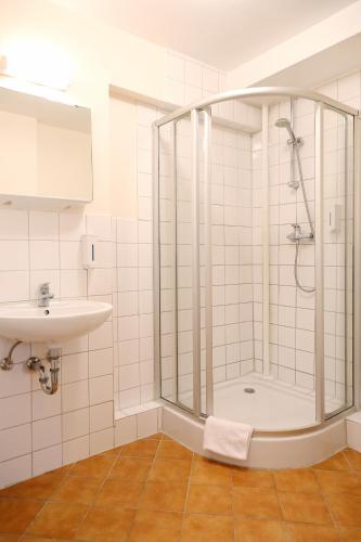 a bathroom with a shower and a sink at Pension Alpha in Frankfurt