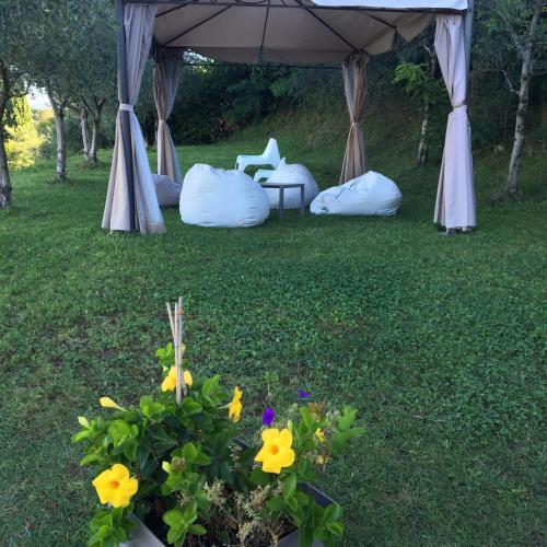 a tent with a chair and flowers in a yard at Agriturismo Casa Aurora in Bussolengo