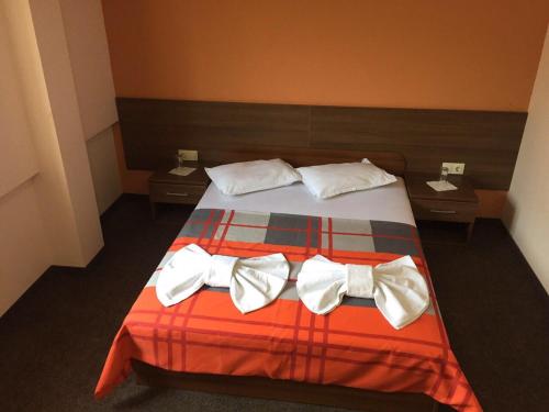 a bedroom with a bed with bow ties on it at Hotel Iris in Plovdiv