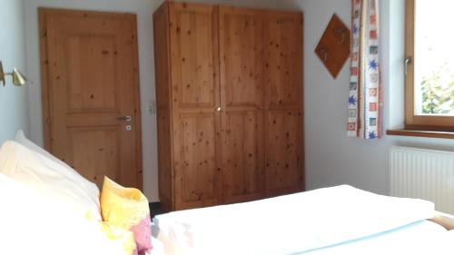 een slaapkamer met een bed en een houten deur bij Apart Martina in Ried im Oberinntal