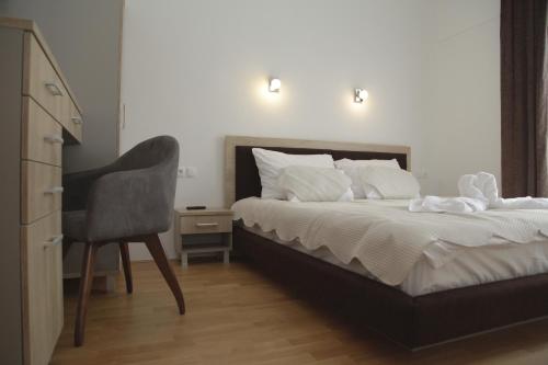 Trnica的住宿－Hotel Korab Trnica，一间卧室配有一张带椅子的床和一张书桌