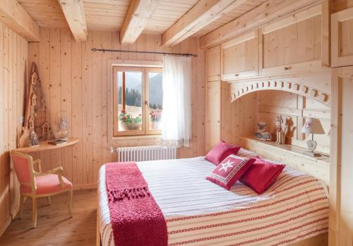 una camera da letto con un grande letto in una camera in legno di Albergo Diffuso Sauris in Sauris Di Sopra a Sauris