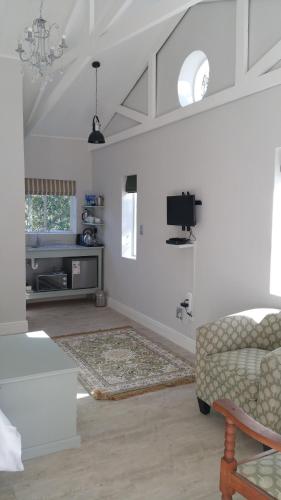 a living room with a couch and a tv at Bergview Guesthouse Swellendam in Swellendam