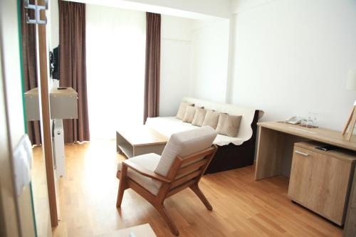 a living room with a white couch and a chair at Hotel Korab Trnica in Trnica