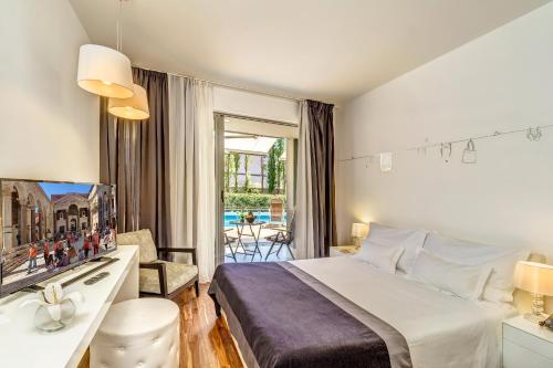 a bedroom with a bed and a desk and a television at Rooms Oasis Life in Split