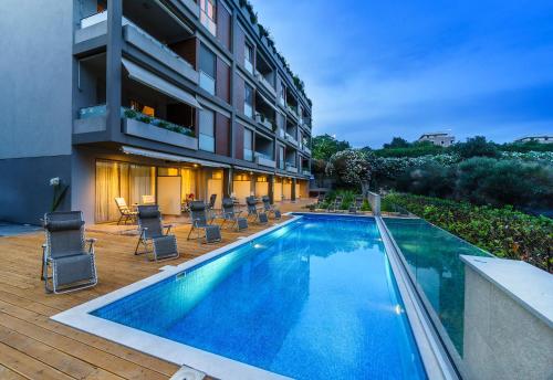 a swimming pool in front of a building at Rooms Oasis Life in Split