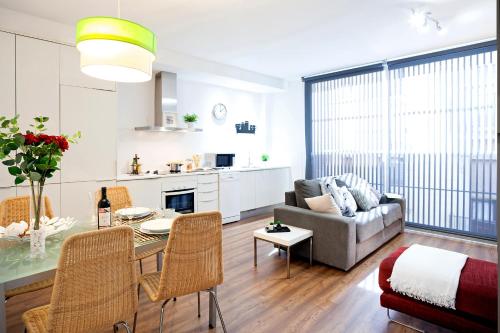 a living room with a table and a couch at Feelathome Poblenou Beach Apartments in Barcelona