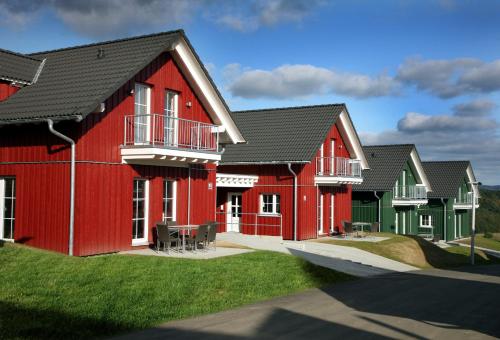 eine Reihe von Häusern mit roten in der Unterkunft Lindner Hotel Nurburgring Ferienpark, part of JdV by Hyatt in Nürburg