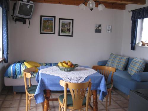 a living room with a table with a bowl of fruit on it at Kellerstöckl Prantner & Haus Wohlauf in Rechnitz