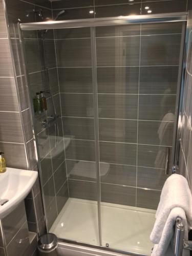a shower with a glass door in a bathroom at Arundel House in Whitby