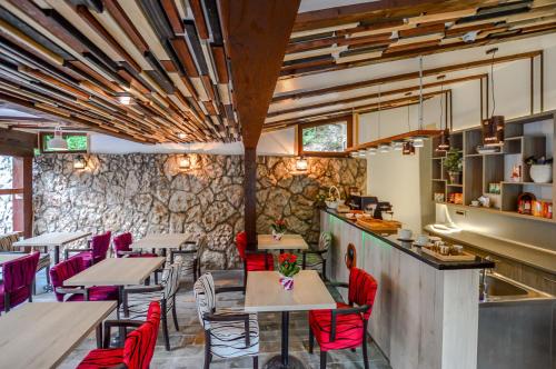 ein Restaurant mit Tischen und Stühlen und einer Steinmauer in der Unterkunft Heritage Hotel Gate of Sarajevo in Sarajevo