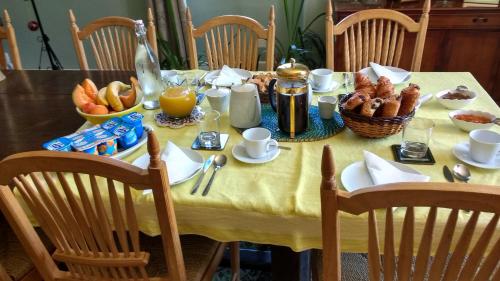 un tavolo con una tovaglia gialla con sopra il cibo per la colazione di Val de Costes a Saint-Maurin