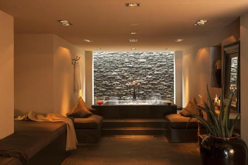 a bathroom with a bath tub in a window at Hotel KÜGLERHOF in Tirolo