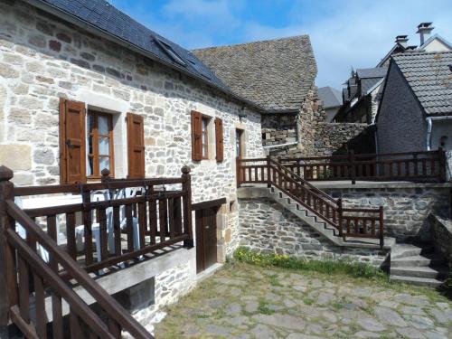 une maison en pierre avec des escaliers et une clôture en bois dans l'établissement Gite COMBRET, à Saint-Germain-du-Teil