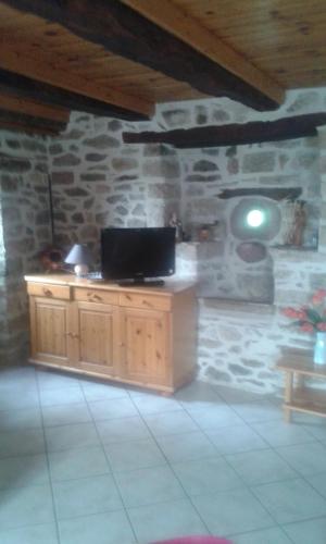 - un salon avec un mur en pierre et un bureau dans l'établissement Gite COMBRET, à Saint-Germain-du-Teil