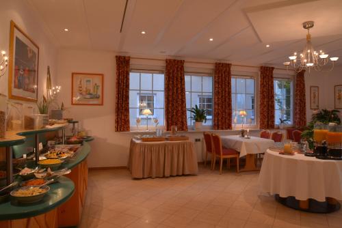 a restaurant with a table and chairs and windows at Parkhotel zum Stern in Oberaula