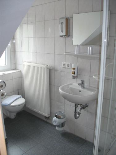 a white bathroom with a sink and a toilet at Hotel Sonnenhof in Sindelfingen