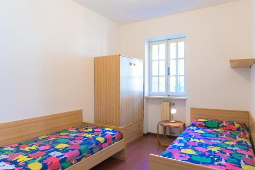 a bedroom with two beds and a window at Appartamento Arancio in Procchio
