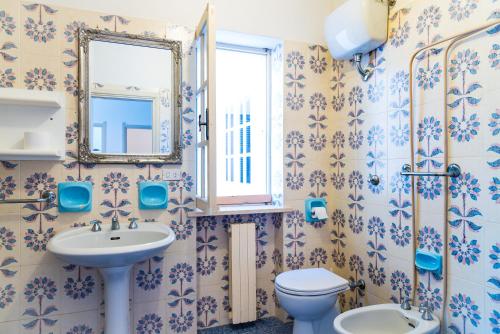 a bathroom with a sink and a toilet and a mirror at Appartamento Arancio in Procchio