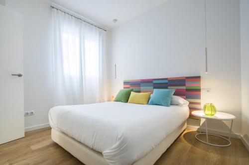 バレンシアにあるValencia Luxury - Boutique Redondaのベッドルーム(大きな白いベッド、カラフルな枕付)