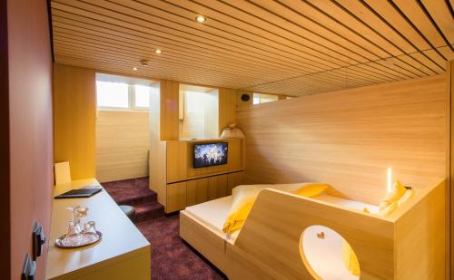 a room with two beds and a television in it at Wohlfühlhotel Hubertushof in Stuben am Arlberg