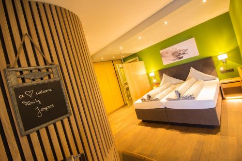 a bedroom with a bed with a sign on the wall at Wohlfühlhotel Hubertushof in Stuben am Arlberg