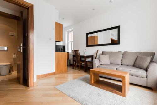 a living room with a couch and a table at Presidential Apartments Kensington in London