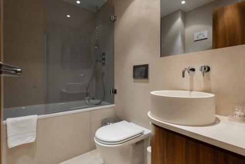 ein Bad mit einem Waschbecken, einem WC und einer Dusche in der Unterkunft Presidential Apartments Kensington in London