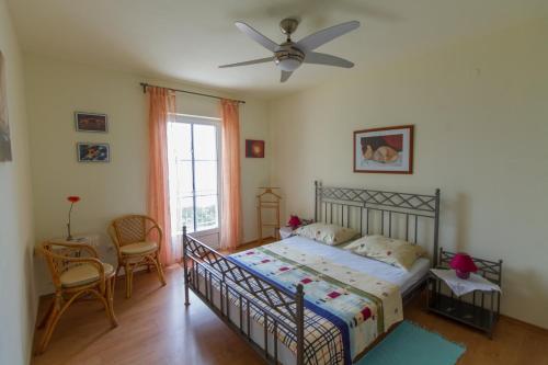 a bedroom with a bed and a ceiling fan at Apartments Ivana in Ravni
