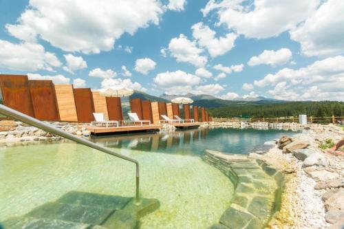 a swimming pool at a resort with chairs in the water at Haus Christophorus in Mariapfarr
