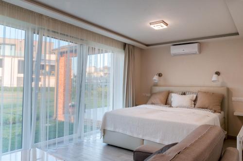 a bedroom with a bed and a large window at MobyDick Luxury Beach Apartment in Siófok