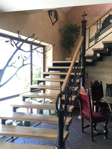 a staircase in a house with a red chair at Villa Audruvis in Joniškis
