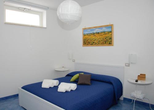 a bedroom with a blue bed with towels on it at Aurora B&B in Agropoli