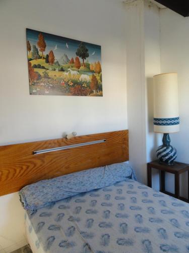 maison de la plage في لو غراو دو روا: غرفة نوم بها سرير ولوحة على الحائط