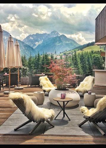 a living room with a table and chairs and mountains at Verwöhn-Wellnesshotel Walserhof in Hirschegg