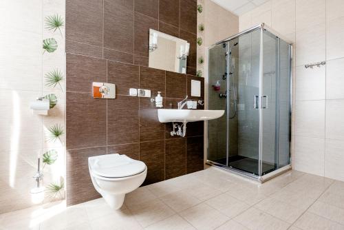 a bathroom with a toilet and a shower and a sink at Hotel Stal in Stalowa Wola