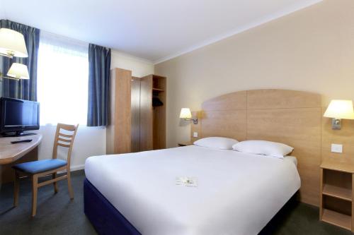 a hotel room with a large white bed and a desk at Campanile Hotel Glasgow SECC Hydro in Glasgow