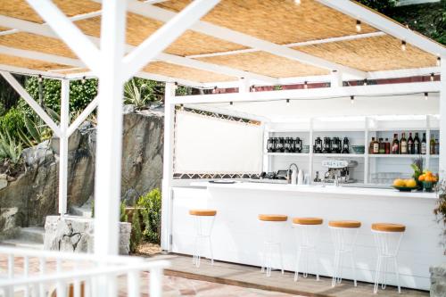 a white bar with stools under a pergola at Les Roches Rouges, a Beaumier hotel in Saint-Raphaël