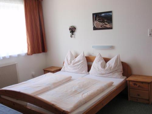 a bedroom with a bed with white sheets and pillows at Ferienwohnungen Kern in Weyregg