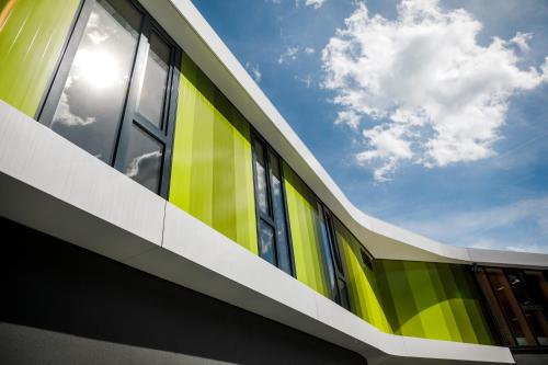a green and yellow building with the sky in the background at Jugendherberge Bayreuth in Bayreuth