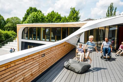a family sitting on the deck of a house at Jugendherberge Bayreuth in Bayreuth