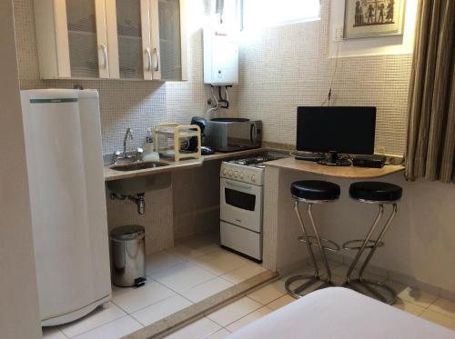 una pequeña cocina con fogones y 2 taburetes en Apartamento Copa Ipa 307, en Río de Janeiro